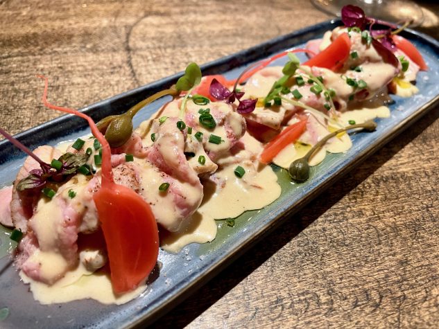Vitello tonnato mit Kapernäpfeln, eingelegten Radieschen und frischen Kräutern